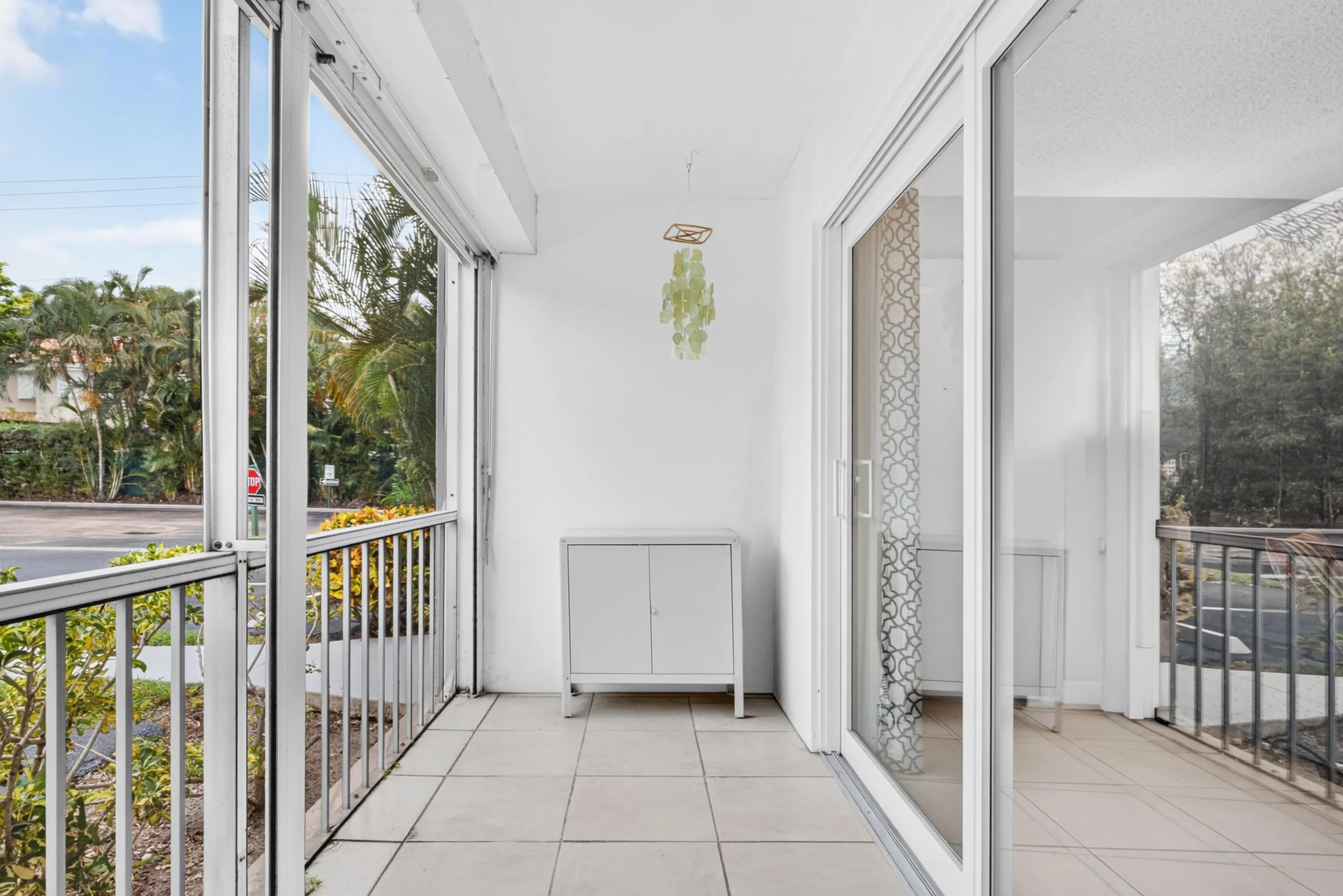 Enclosed patio featuring floor-to-ceiling glass panels and tile flooring