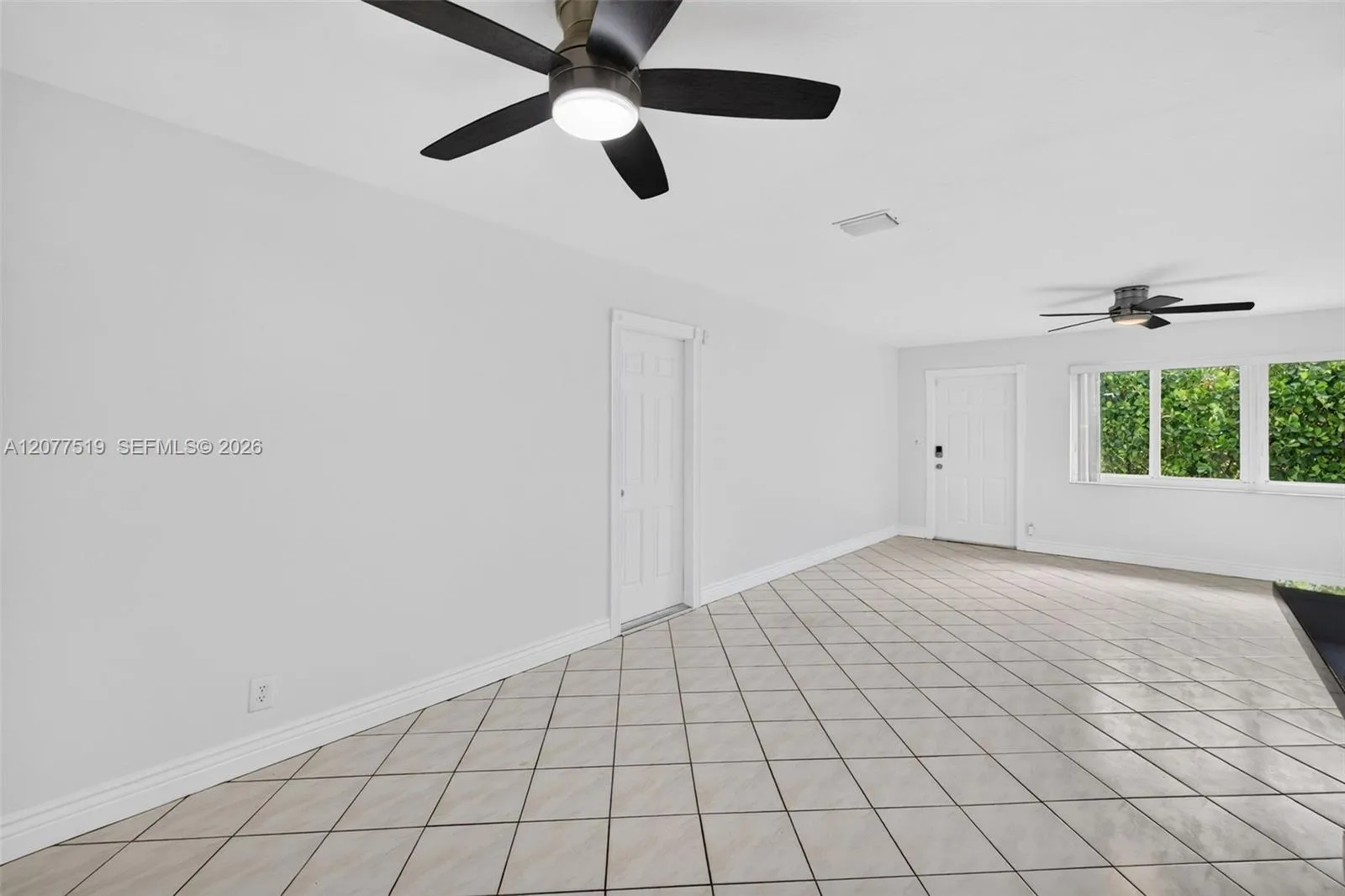 Bright living room featuring tile flooring, neutral finishes and ample natural light.