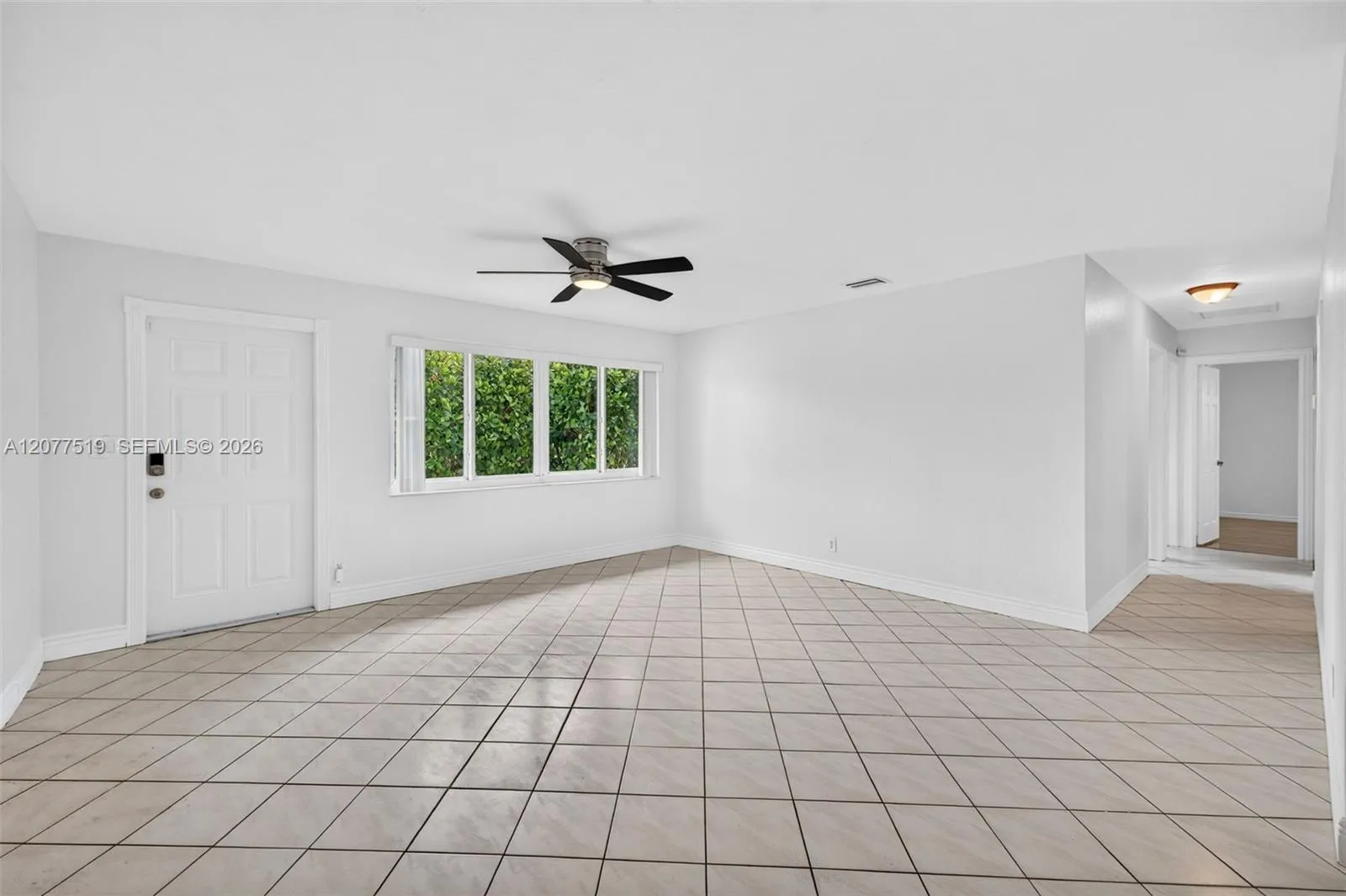 Bright living room featuring tile flooring, neutral finishes and ample natural light.