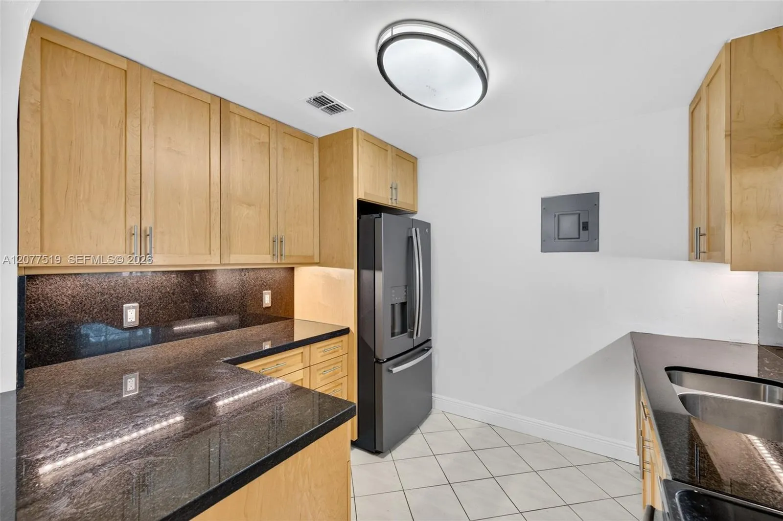 Functional kitchen offering an electric range, refrigerator, dishwasher and modern finishes.