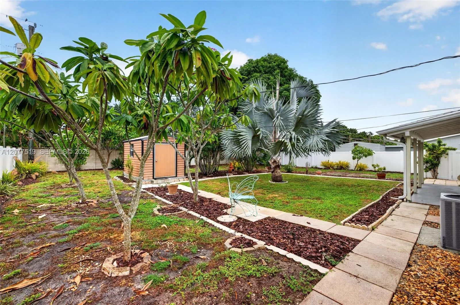 Expansive backyard with mature palms, covered patio space and room for a pool, RV or boat trailer.