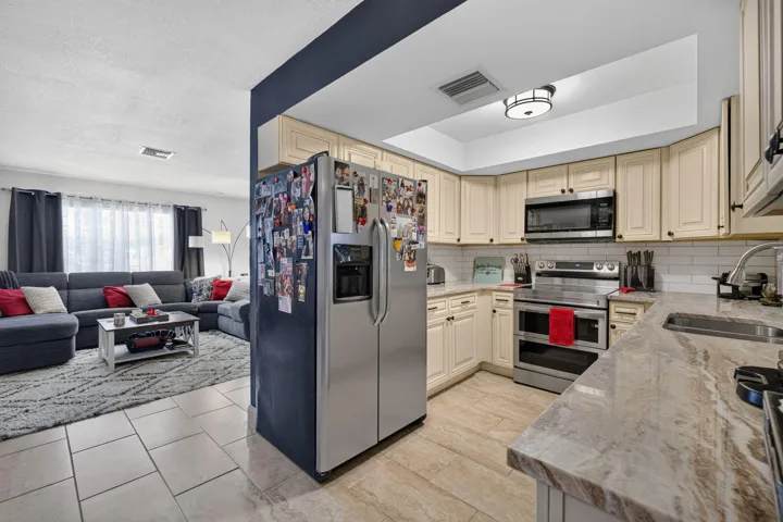 Kitchen featuring light-toned cabinetry, stainless steel appliances, and a subway tile backsplash