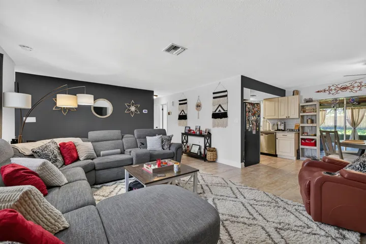 Open-concept living space with a distinct accent wall and tiled flooring