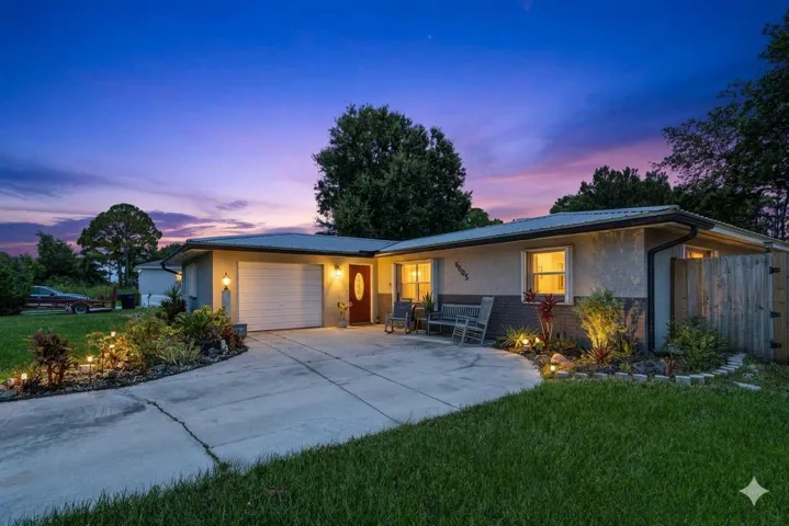 Contemporary single-story residence with a metal roof, attached garage, and a concrete driveway