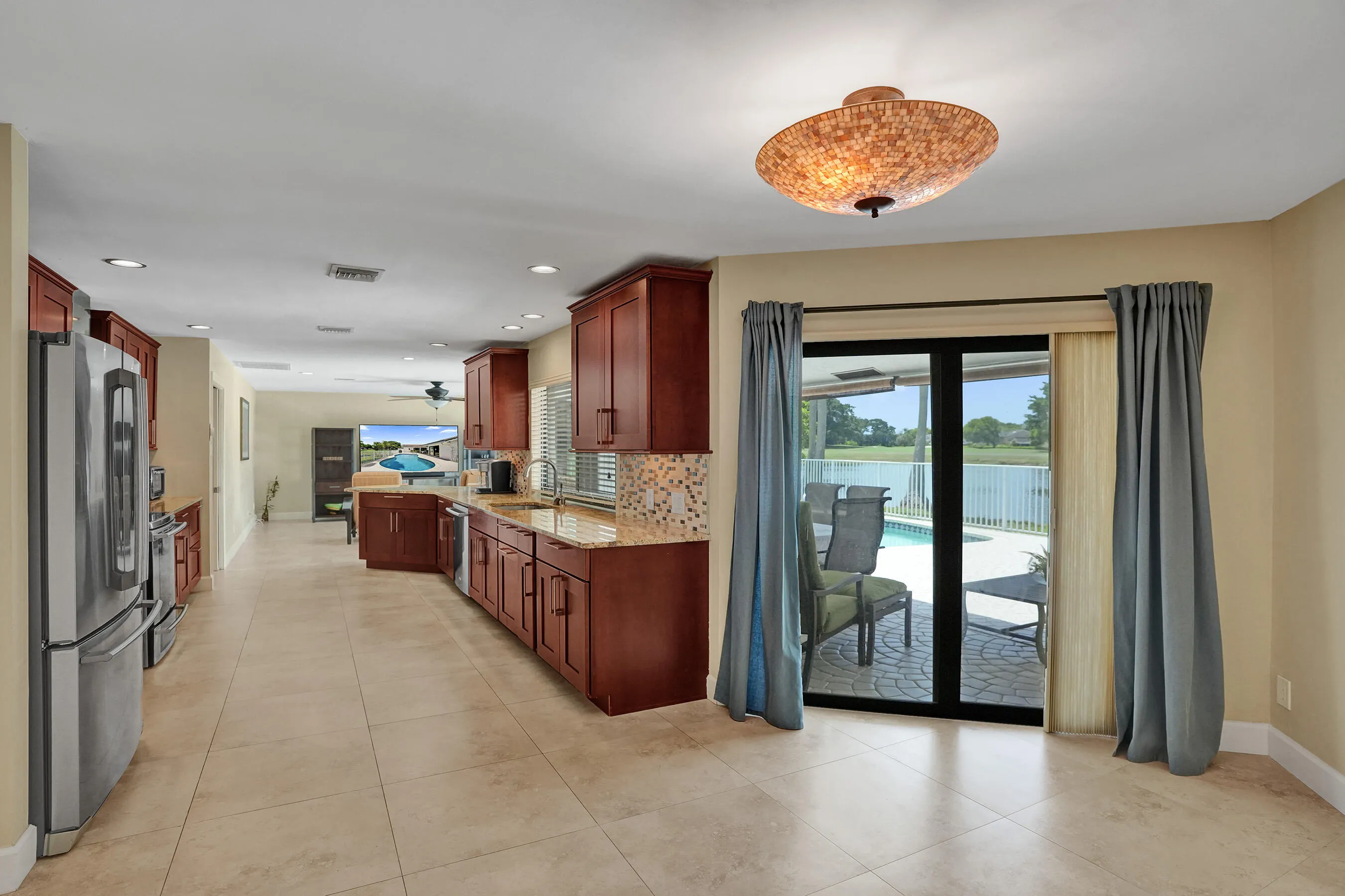 Spacious kitchen with wood-finish cabinetry, stainless steel appliances, and tile flooring