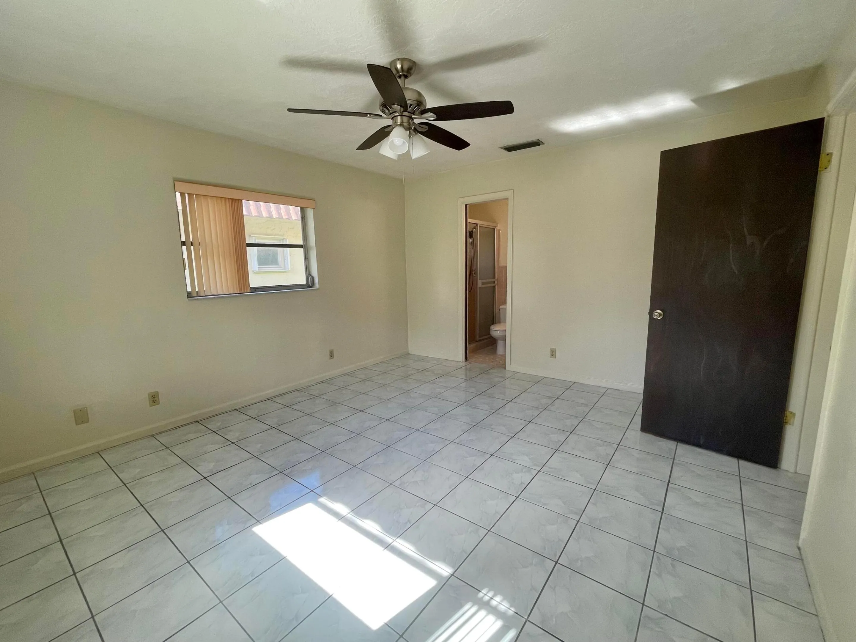 Light-toned tile flooring, ceiling fan with integrated lighting, and window with blinds