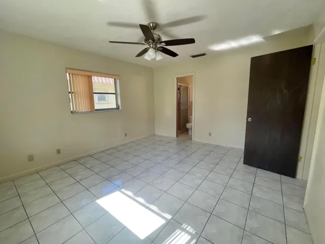 Light-toned tile flooring, ceiling fan with integrated lighting, and window with blinds