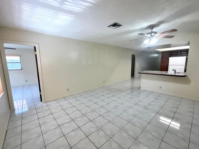 Tile flooring, ceiling fan, wood-finish cabinetry, built-in refrigerator, and pass-through counter
