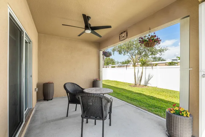 Screened patio featuring a ceiling fan, concrete flooring, and a sliding glass door