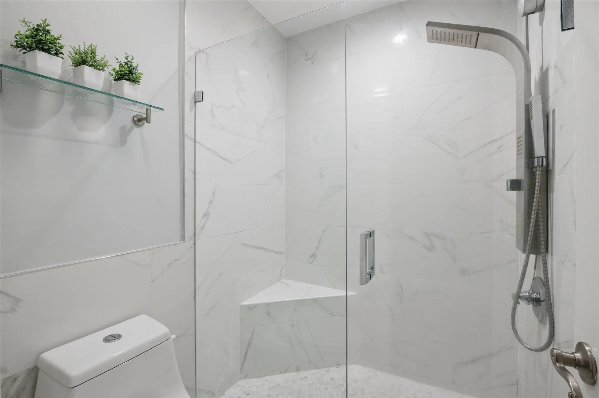 Modern tiled shower with frameless glass and oversized rain head