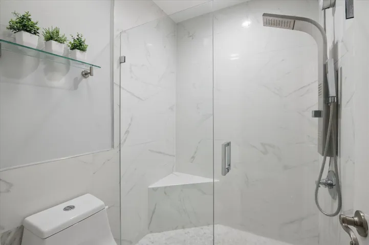 Modern tiled shower with frameless glass and oversized rain head