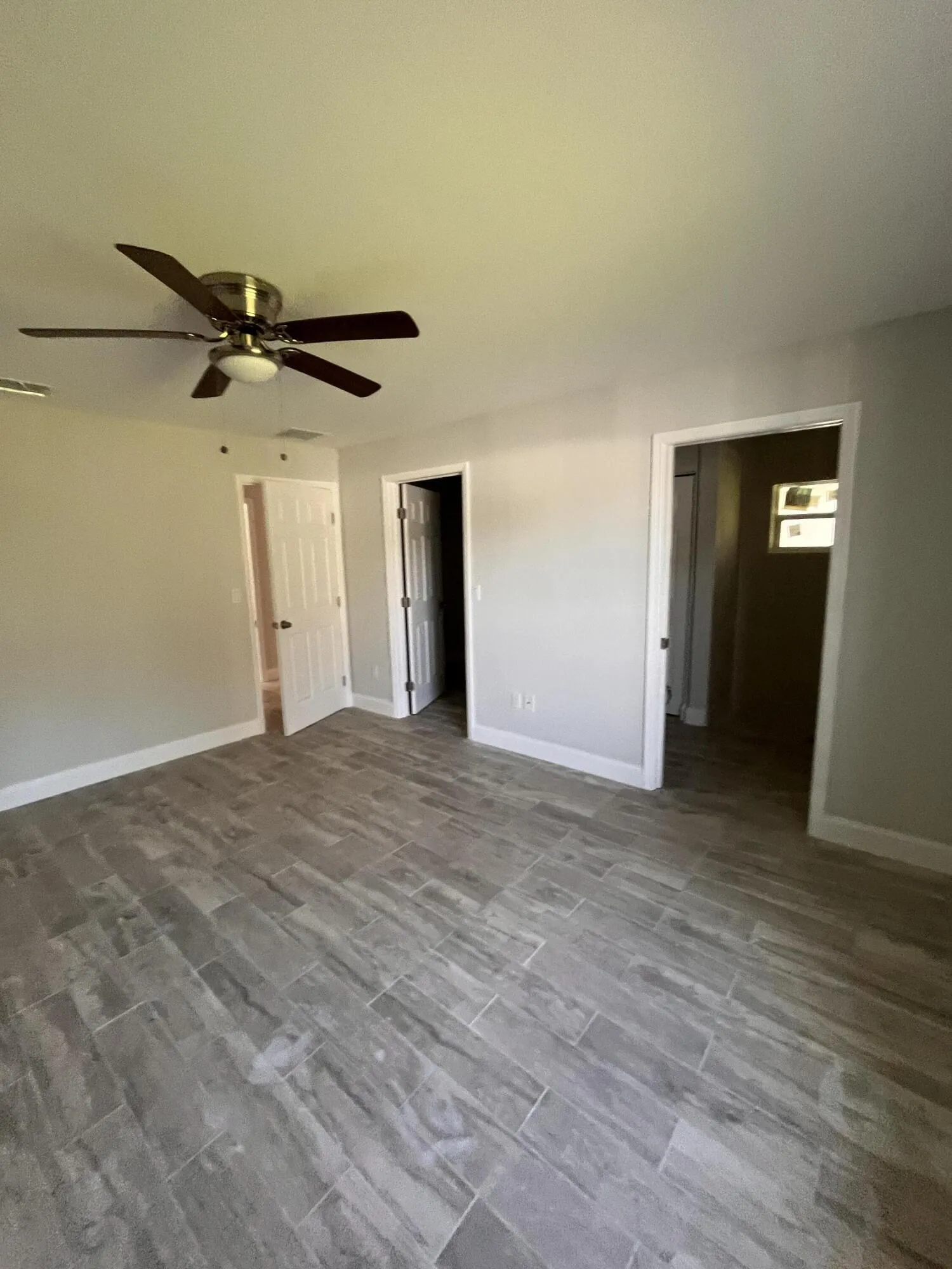 Porcelain tile flooring, neutral wall tones, and an overhead ceiling fan with integrated​​‌​​​​‌​​‌‌​‌‌​​​‌‌​‌​‌​‌​​​‌​​ lighting