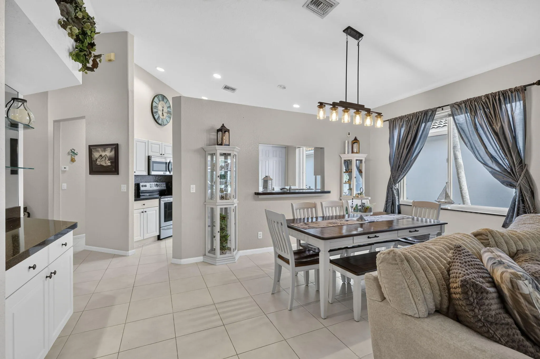 Vaulted ceilings, tile flooring, recessed lighting, and a modern linear chandelier
