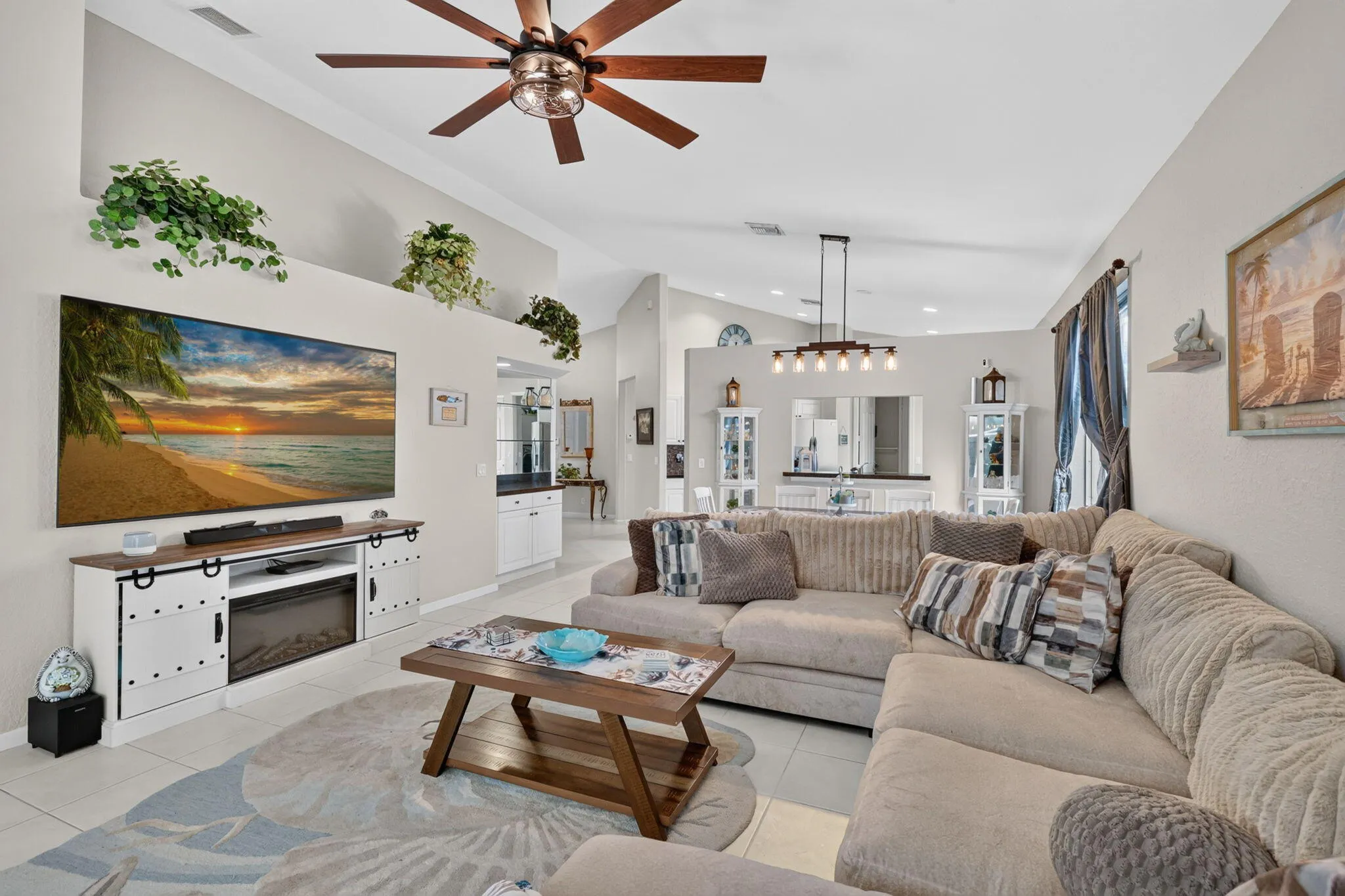 Vaulted ceilings, large ceiling fan, recessed wall ledges, tiled flooring, and a modern linear chandelier