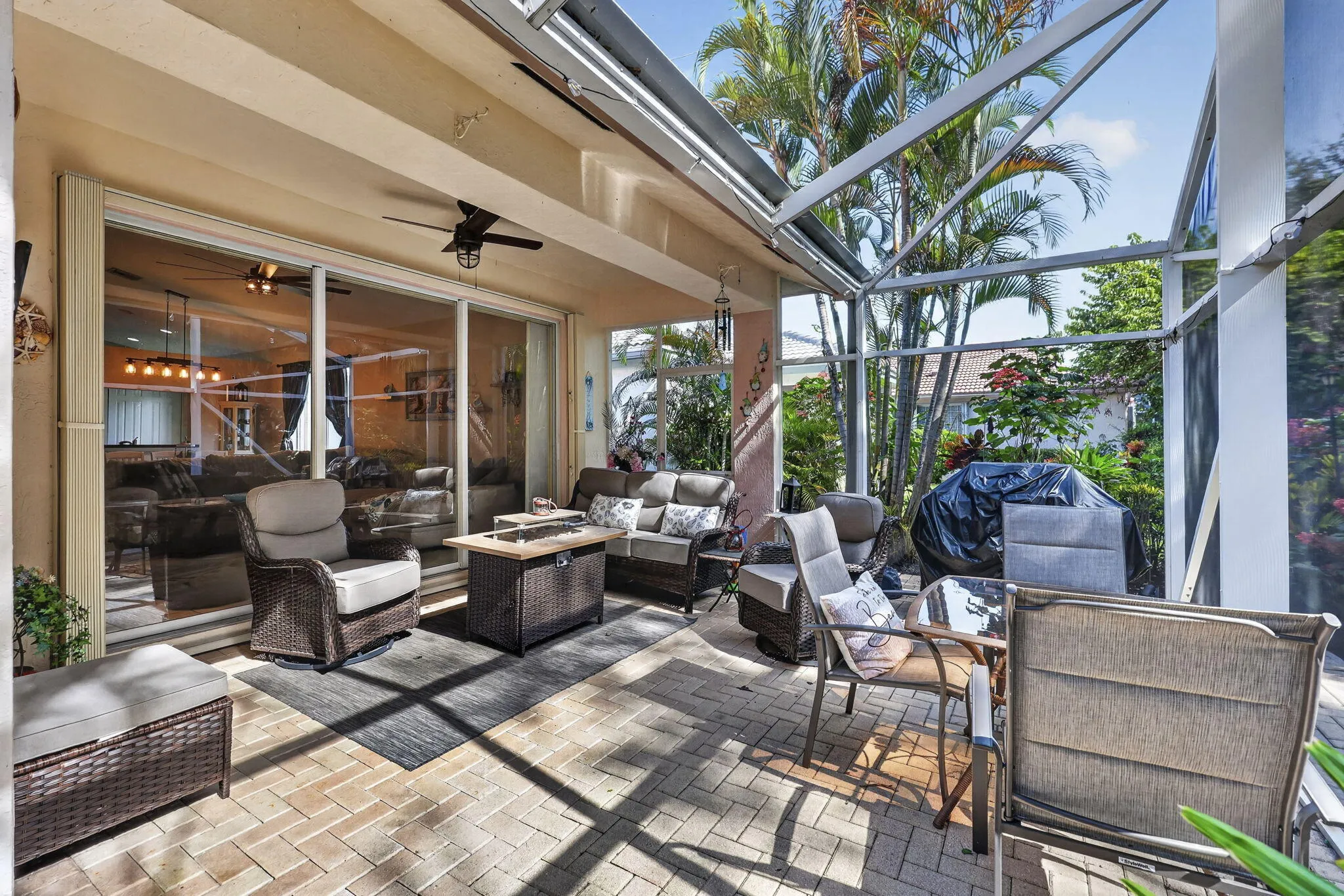 Screened patio with a paver floor, ceiling fan, and sliding glass door access