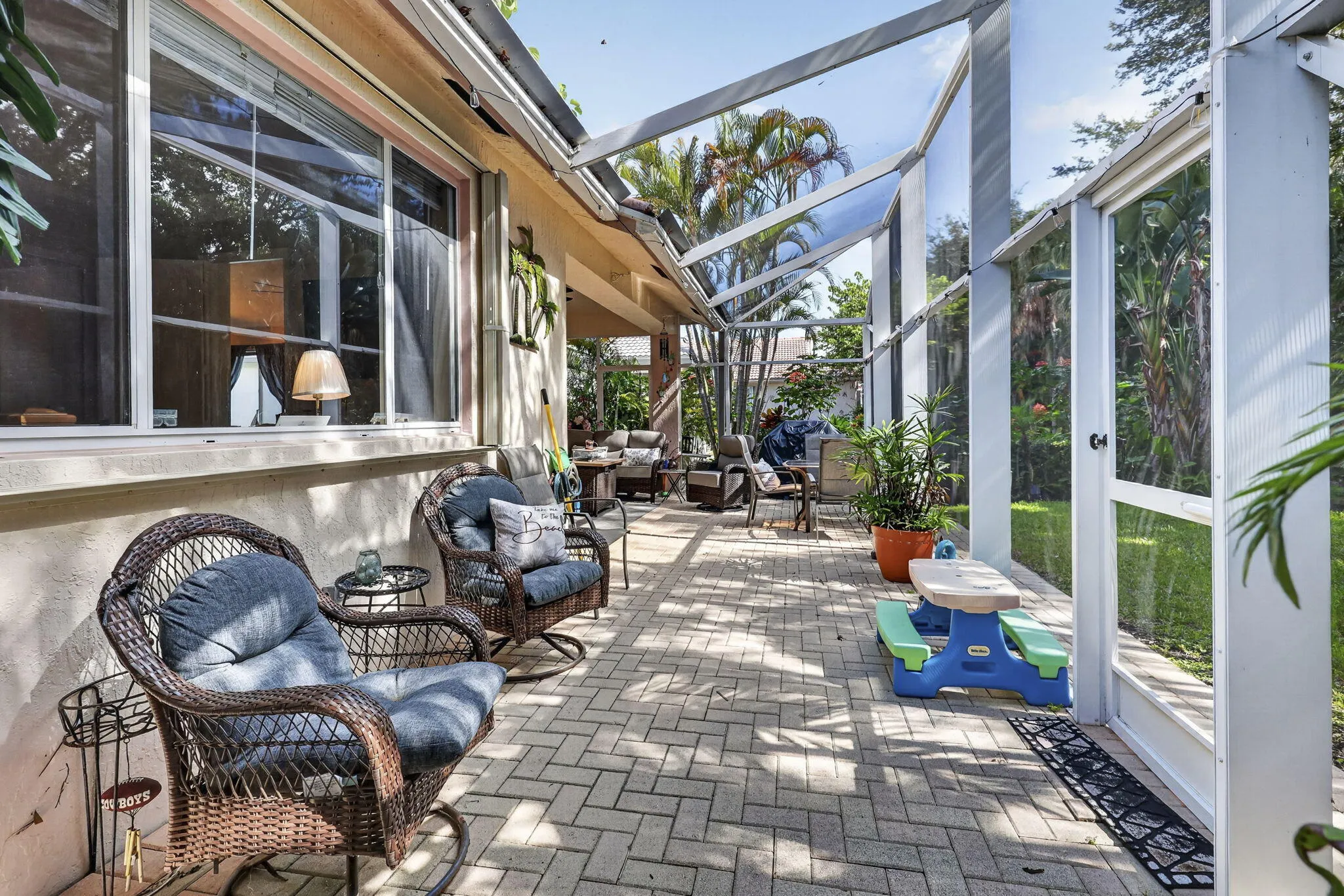 Screened outdoor living area featuring a paver patio, full-height screening, and an exterior window