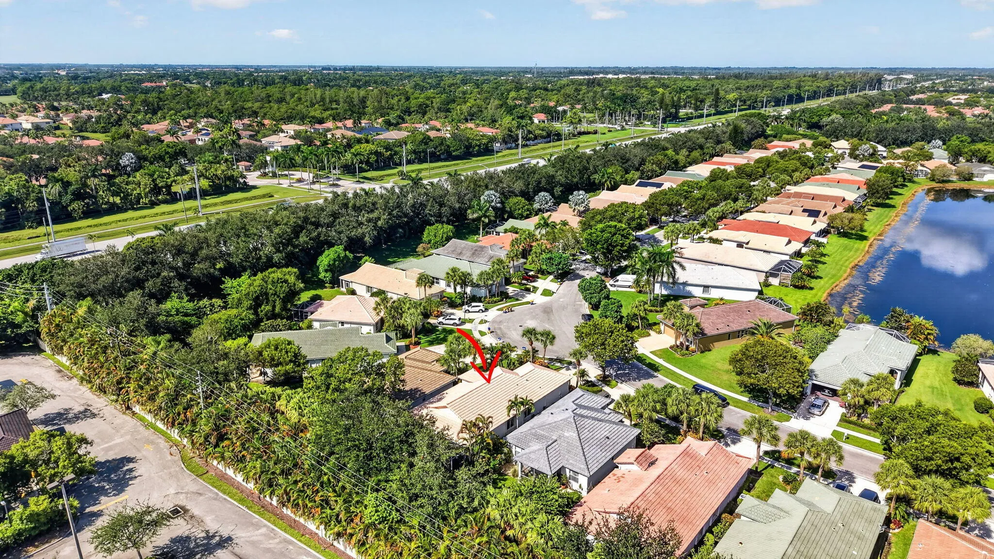 Residential community with mature landscaping, water feature, and paved streets