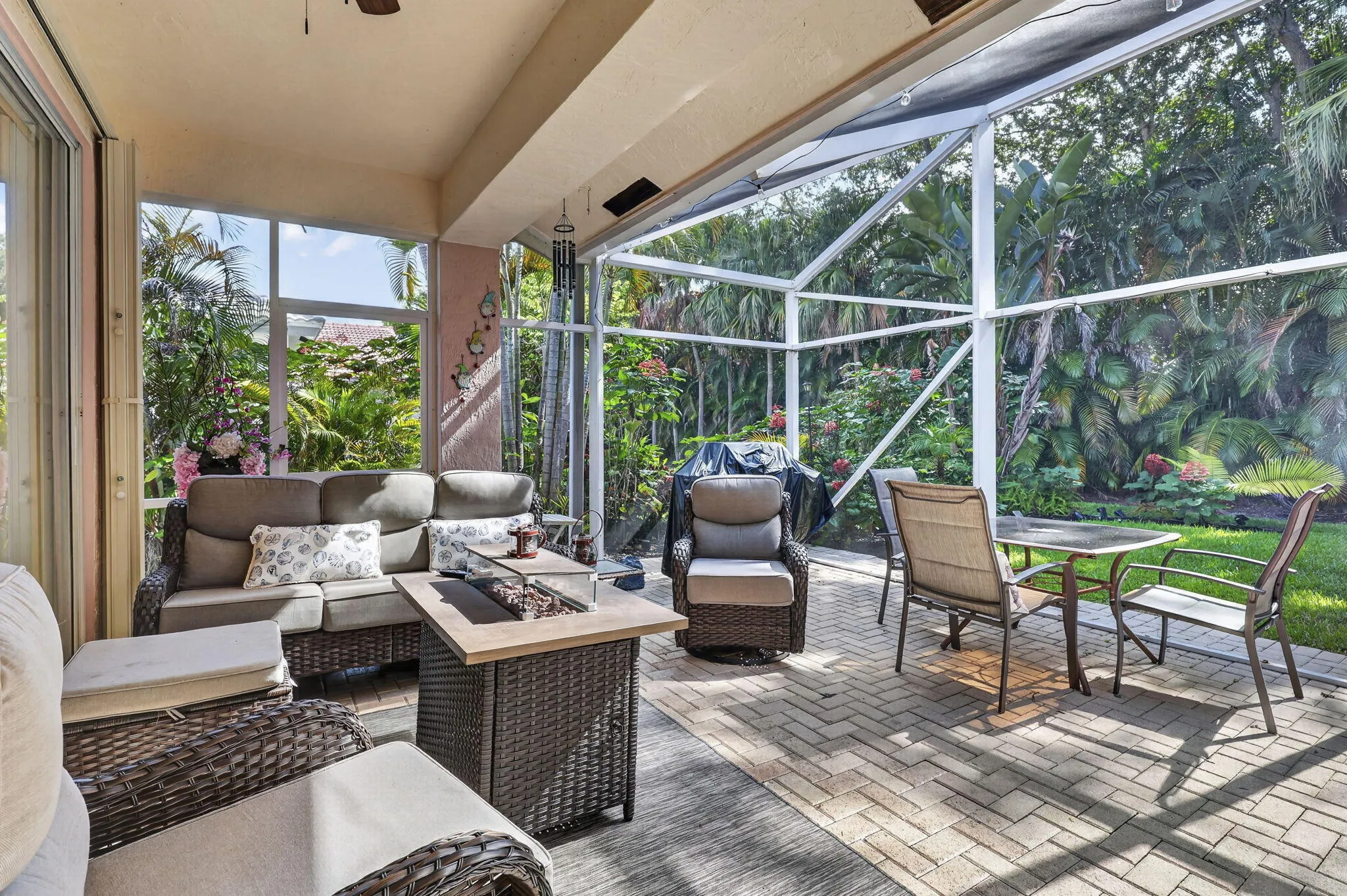 Screened patio with a covered section, paver flooring, and abundant natural light