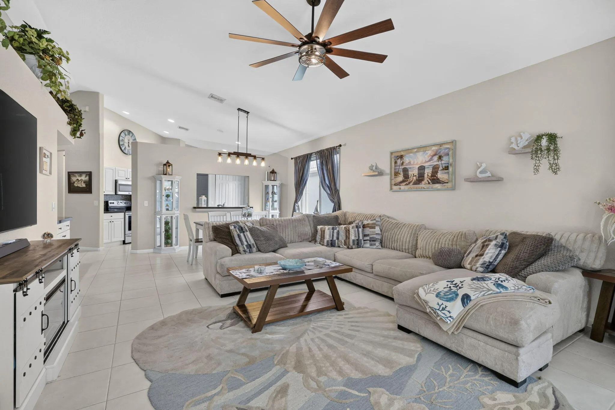 Vaulted ceilings, a dark wood-finish ceiling fan, and tile flooring