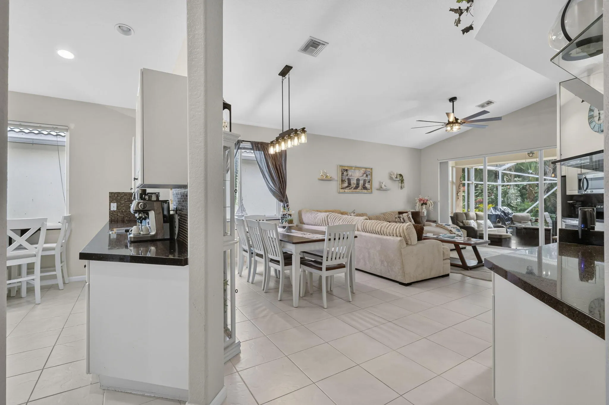 Open-concept living space featuring high ceilings, tile flooring, and sliding glass doors