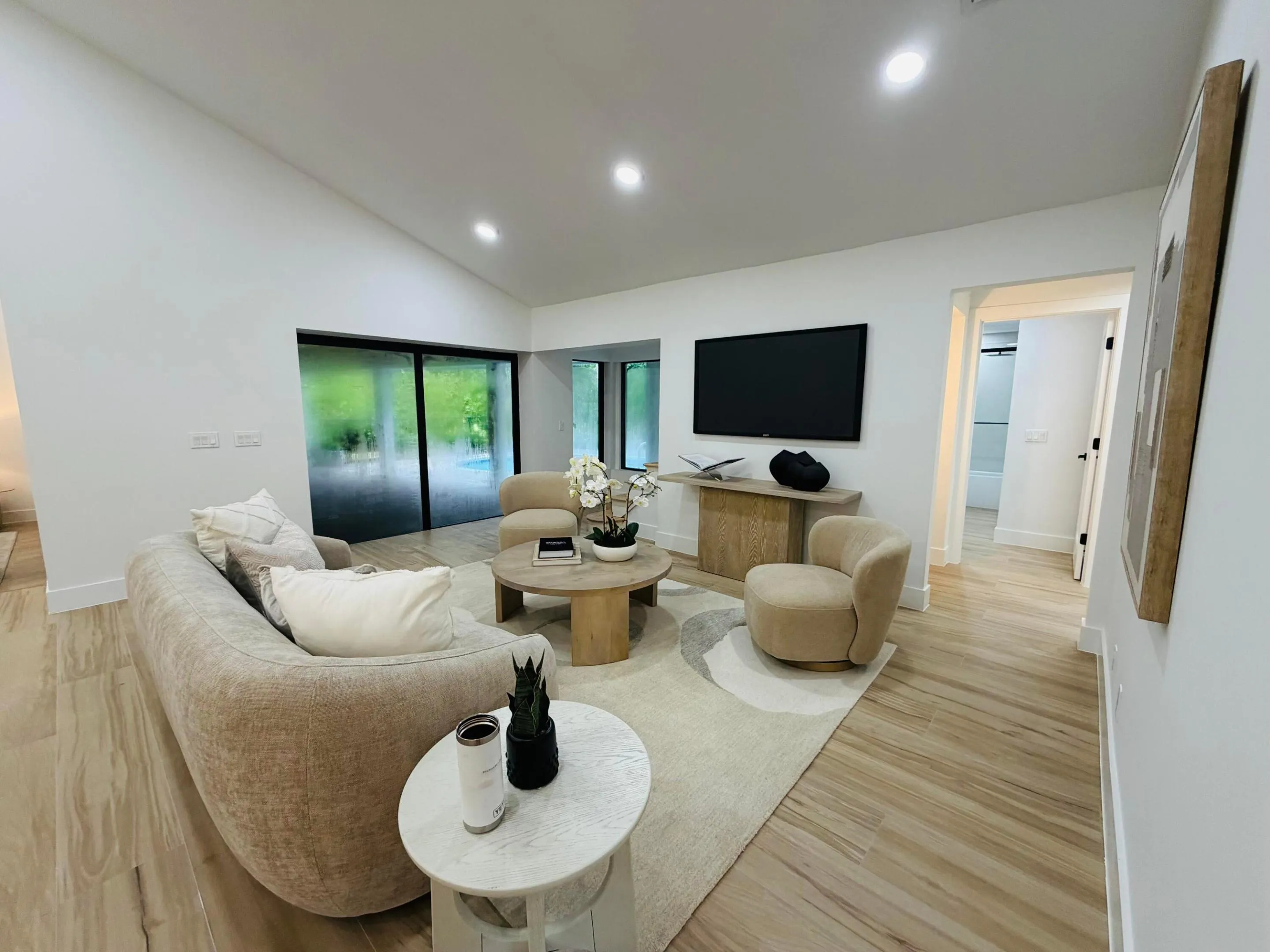 Vaulted ceilings, recessed lighting, wood-finish flooring, and a built-in wall-mounted television