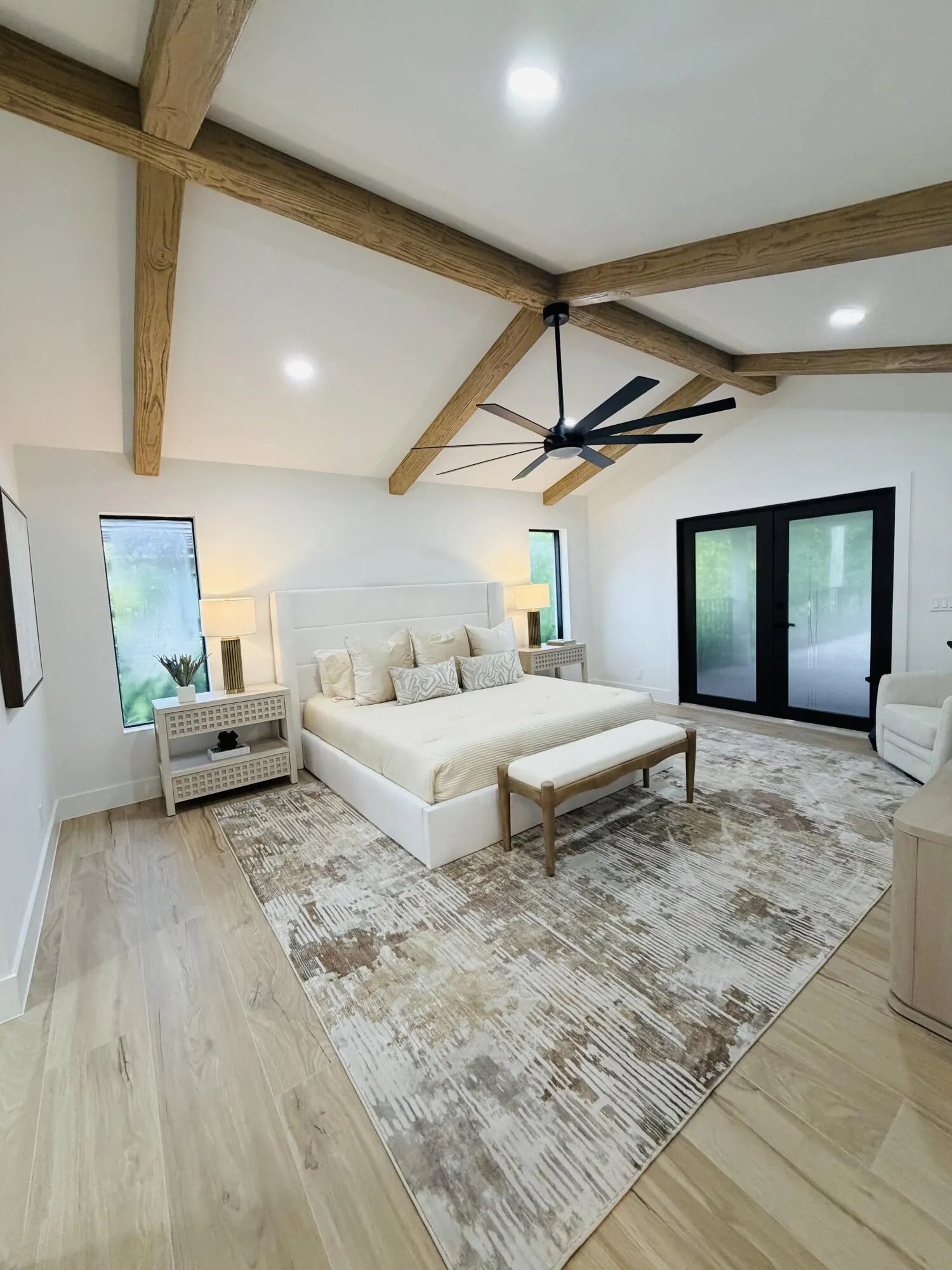 Vaulted ceiling with exposed wood beams, wood-finish flooring, recessed lighting, and a contemporary ceiling fan