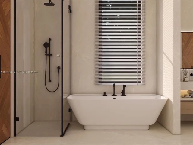 Bright bathroom featuring glass-enclosed shower, freestanding tub, and natural light.