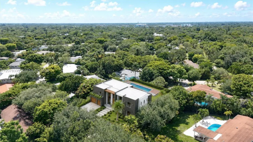 Bird's-eye view of the residence and its verdant, tree-lined neighborhood setting.