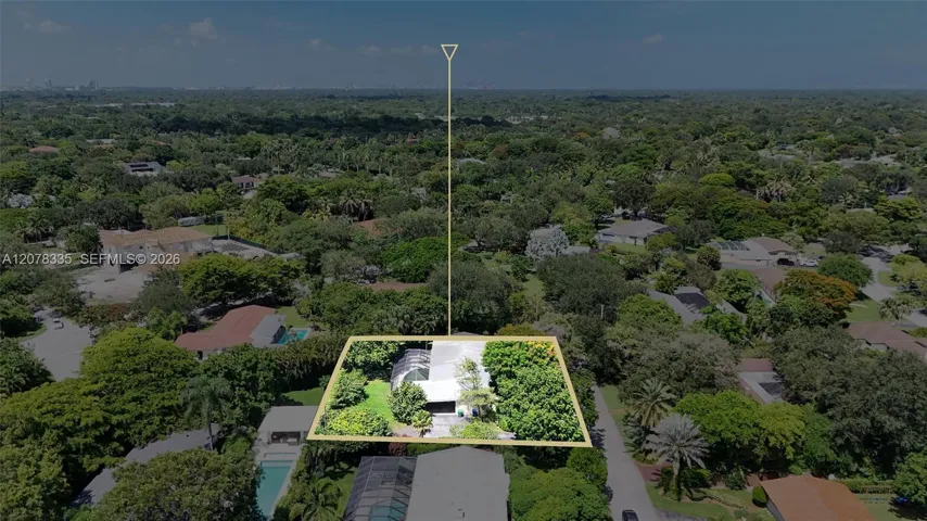 Drone view showcasing the home's layout, spacious lot boundaries, and surrounding lush greenery.
