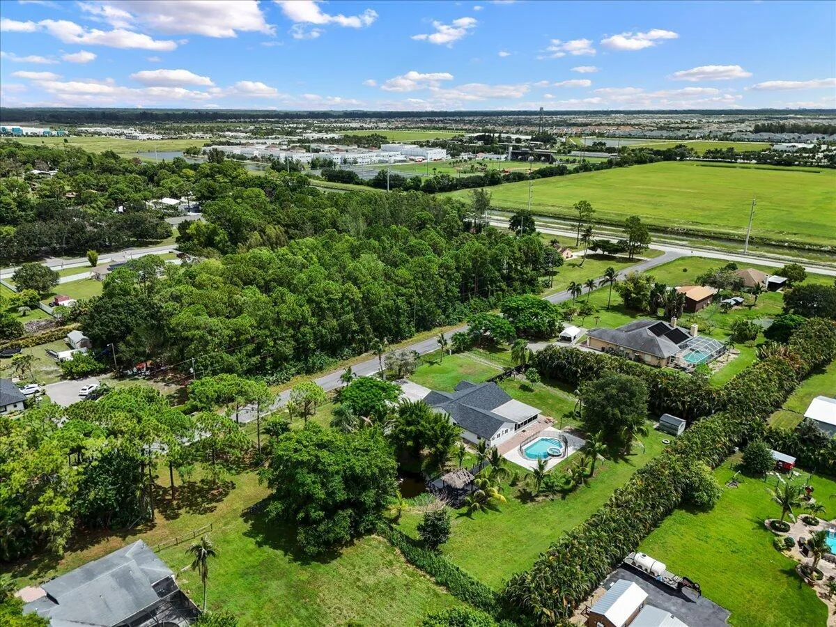 From above, your own piece of Florida paradise comes into view—spacious grounds, a private pool and spa, tropical surroundings, and a peaceful pond with its signature tiki hut. This is the space, privacy and laid-back Loxahatchee lifestyle that makes coming home feel like an escape.