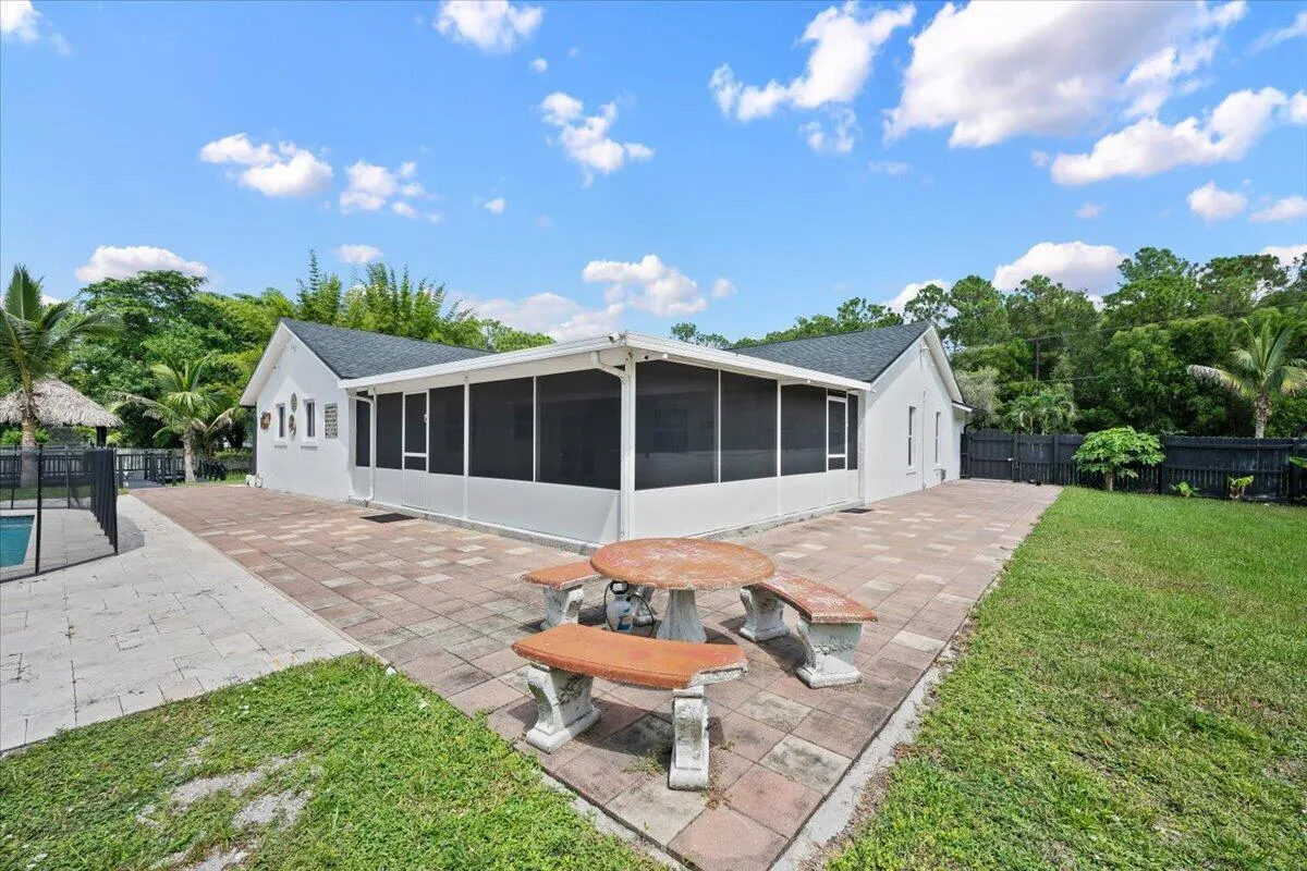 Step outside and see just how much room there is to enjoy. The expansive screened porch extends into a generous paved outdoor area, creating an easy connection between the home, pool, and wide-open backyard.