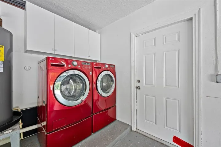 Even the everyday essentials have their place. The garage features a dedicated laundry area with built-in cabinetry and a convenient utility sink, keeping household tasks organized and tucked away.