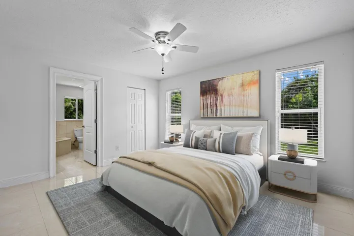 Your private retreat awaits. Bright, peaceful and thoughtfully connected to the ensuite bath, the primary suite offers a comfortable place to unwind while tropical views just outside the windows remind you—you’re home in Florida.