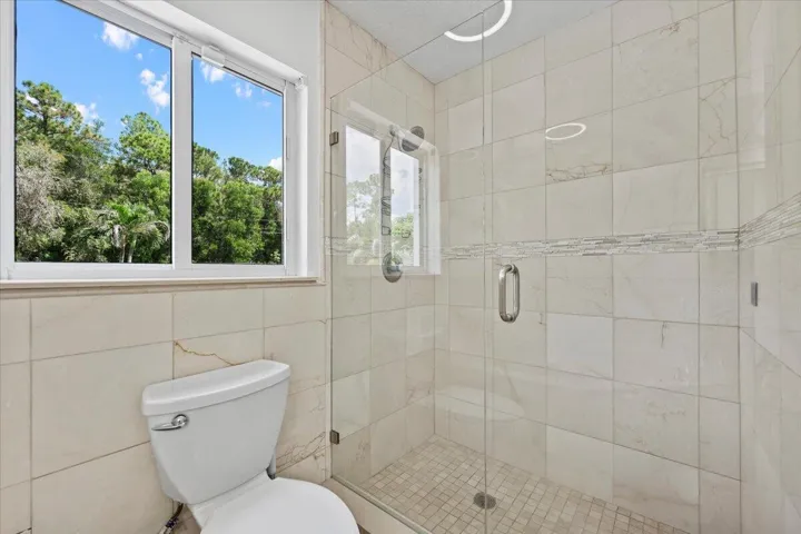 Start the morning refreshed or wash away the day. The glass-enclosed walk-in shower, surrounded by tile and natural light, completes this inviting primary retreat.