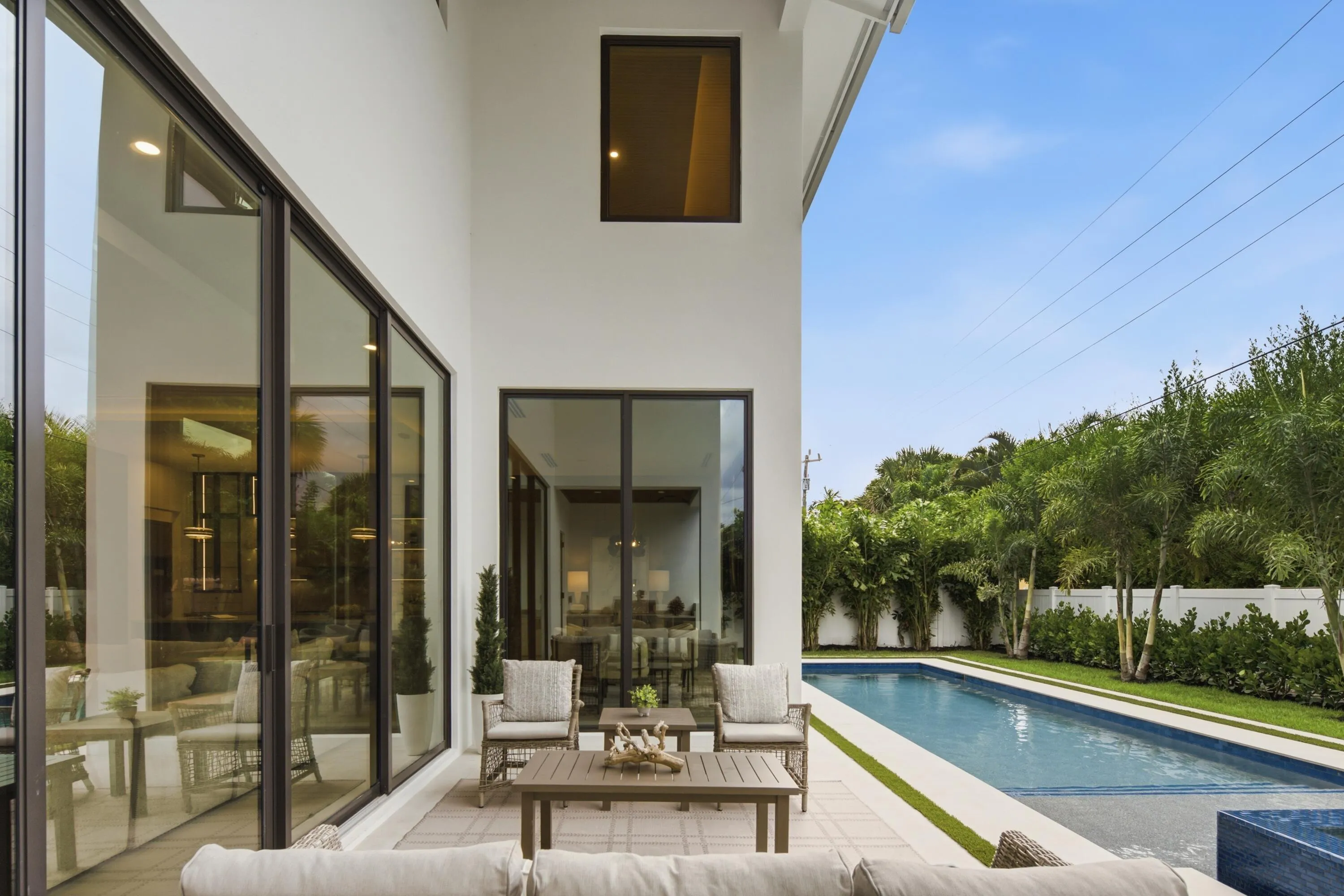 Outdoor patio featuring large format pavers, a rectangular swimming pool, and a defined green space
