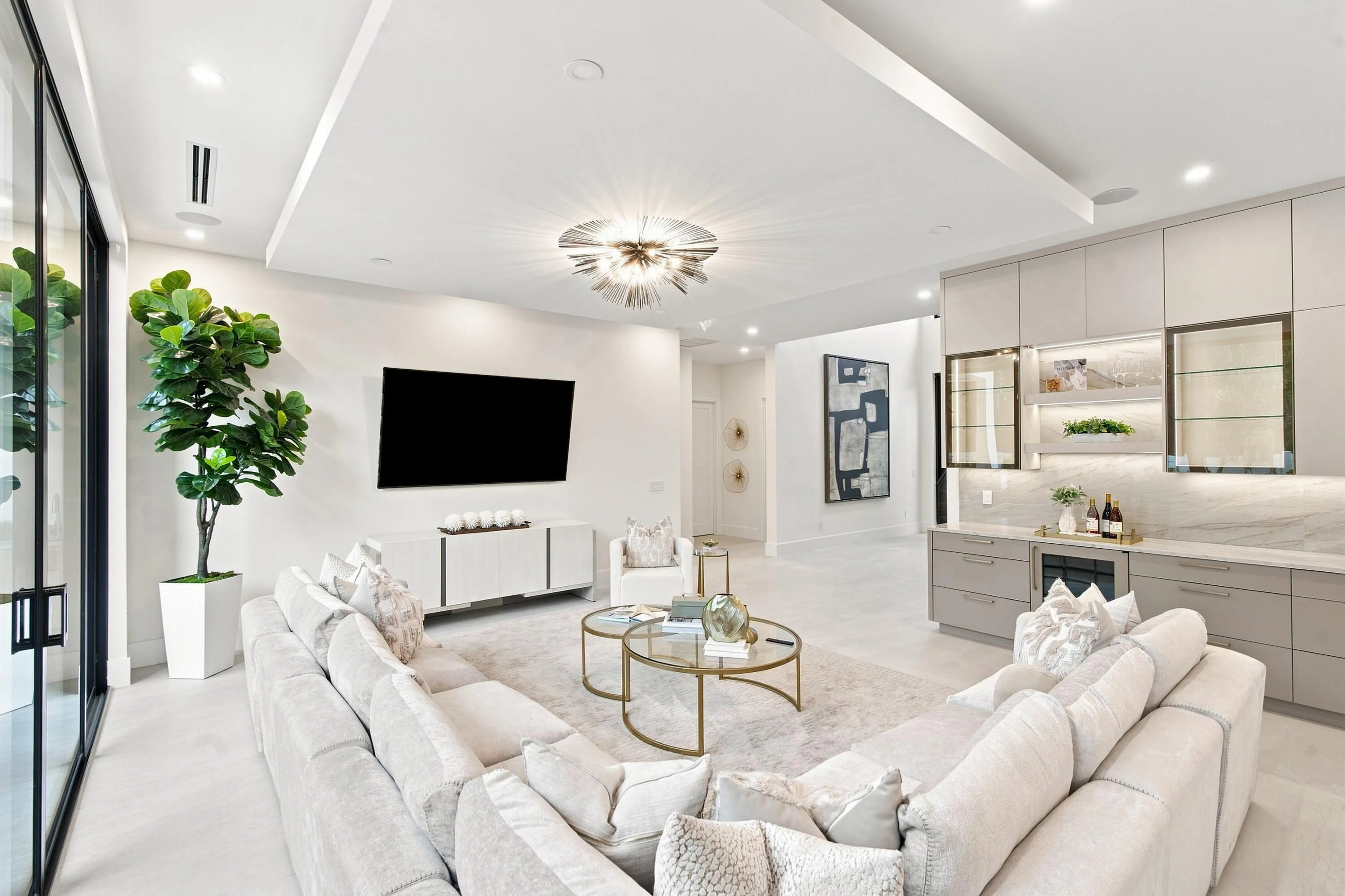 Spacious living area featuring a ceiling-mounted light fixture, recessed lighting, and large format tile flooring