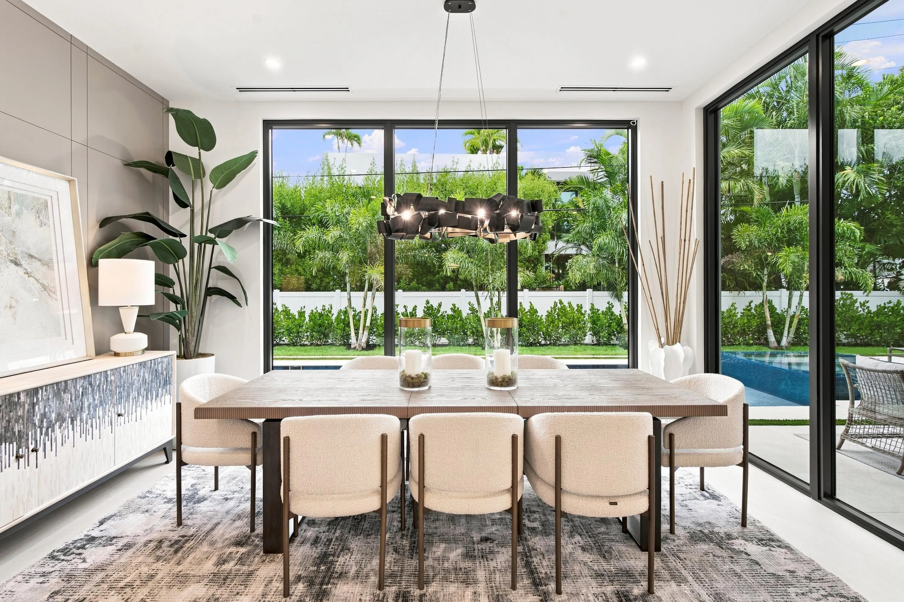 Dining area featuring a dark wood-finish table, a contemporary chandelier, and full-height windows