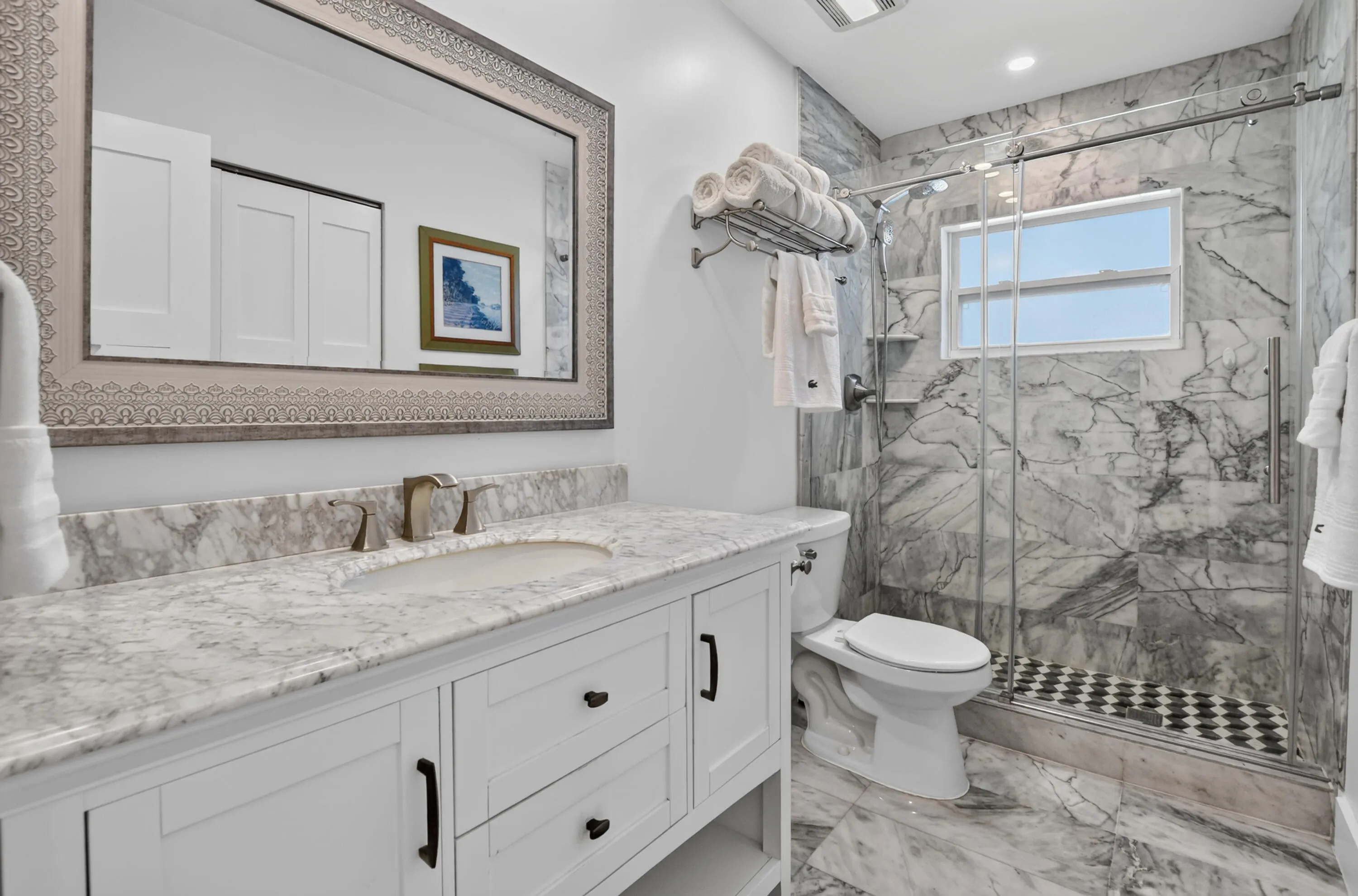 Main bathroom features marble floors, counters and shower