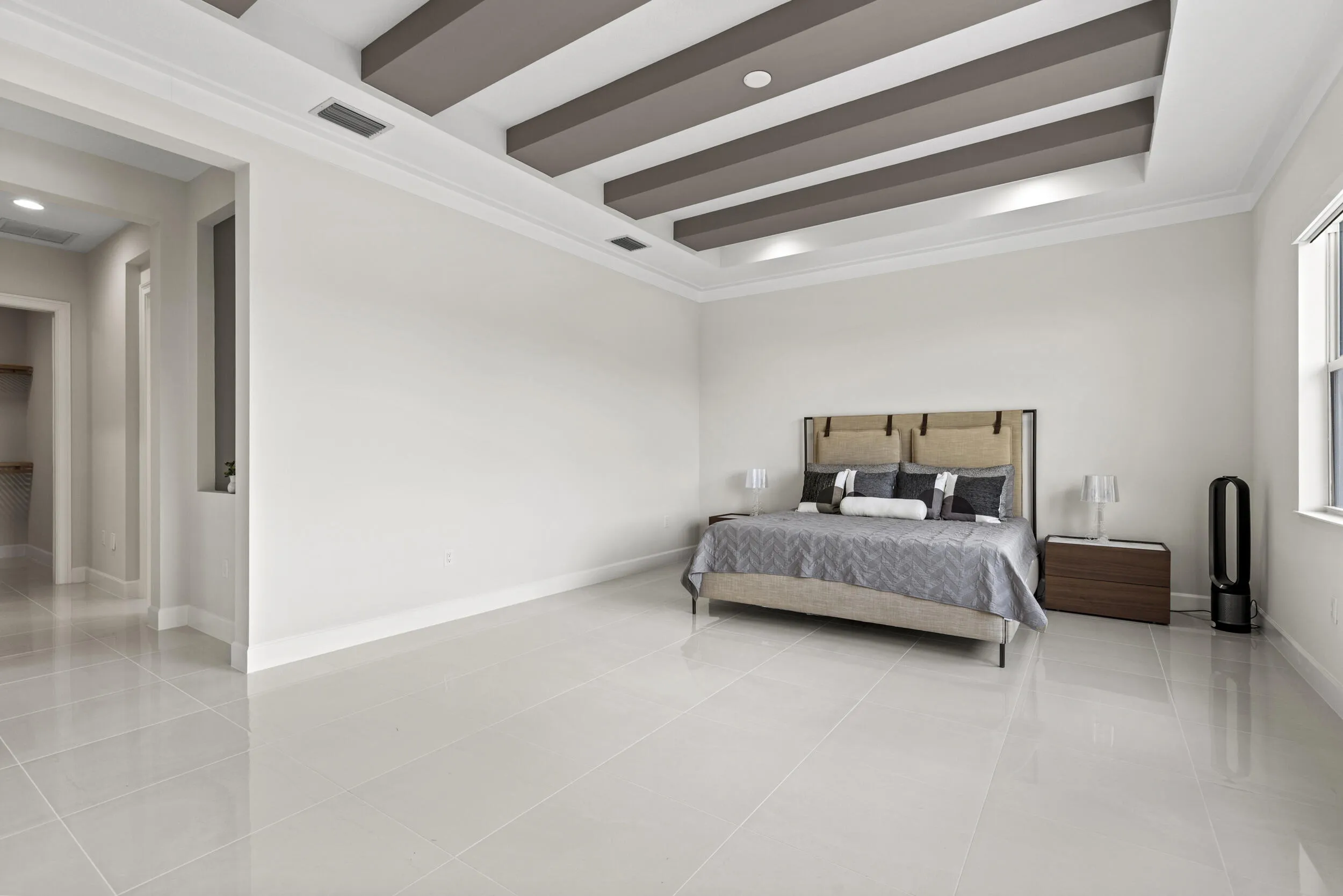 Owner's Suite featuring tray ceiling with contrasting beams and recessed lighting