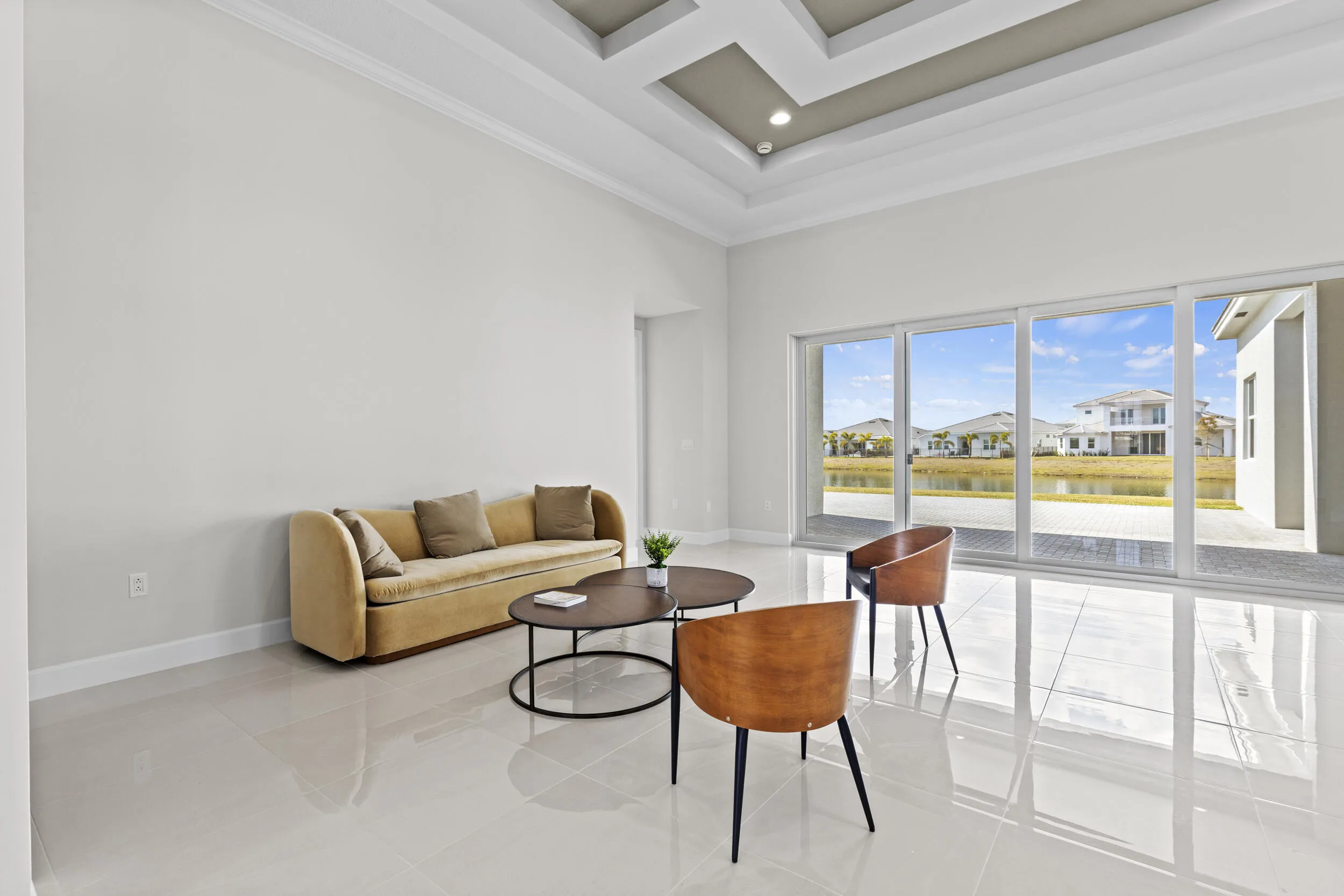 Tray ceiling with recessed lighting, large format tile flooring, and expansive sliding glass doors opening to a patio
