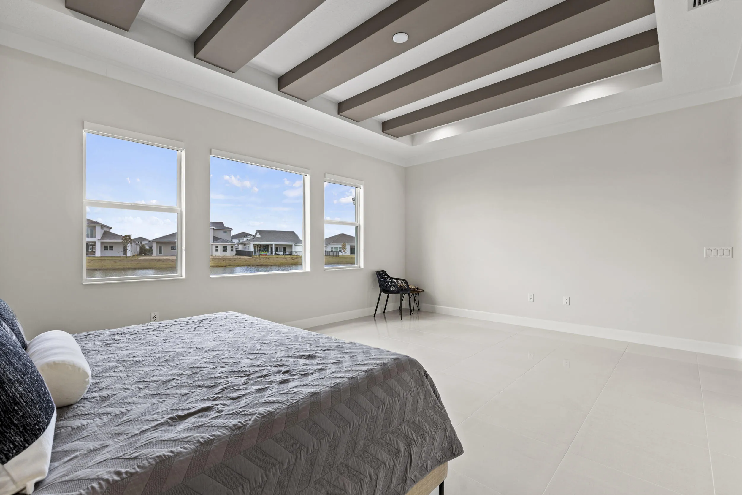 Owner's Suite featuring tray ceiling with recessed lighting and decorative beams