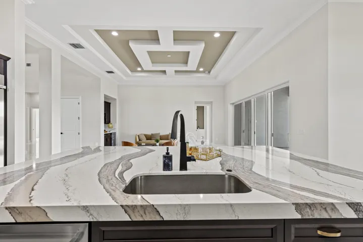 Expansive kitchen island featuring a deep undermount sink and a matte black gooseneck faucet
