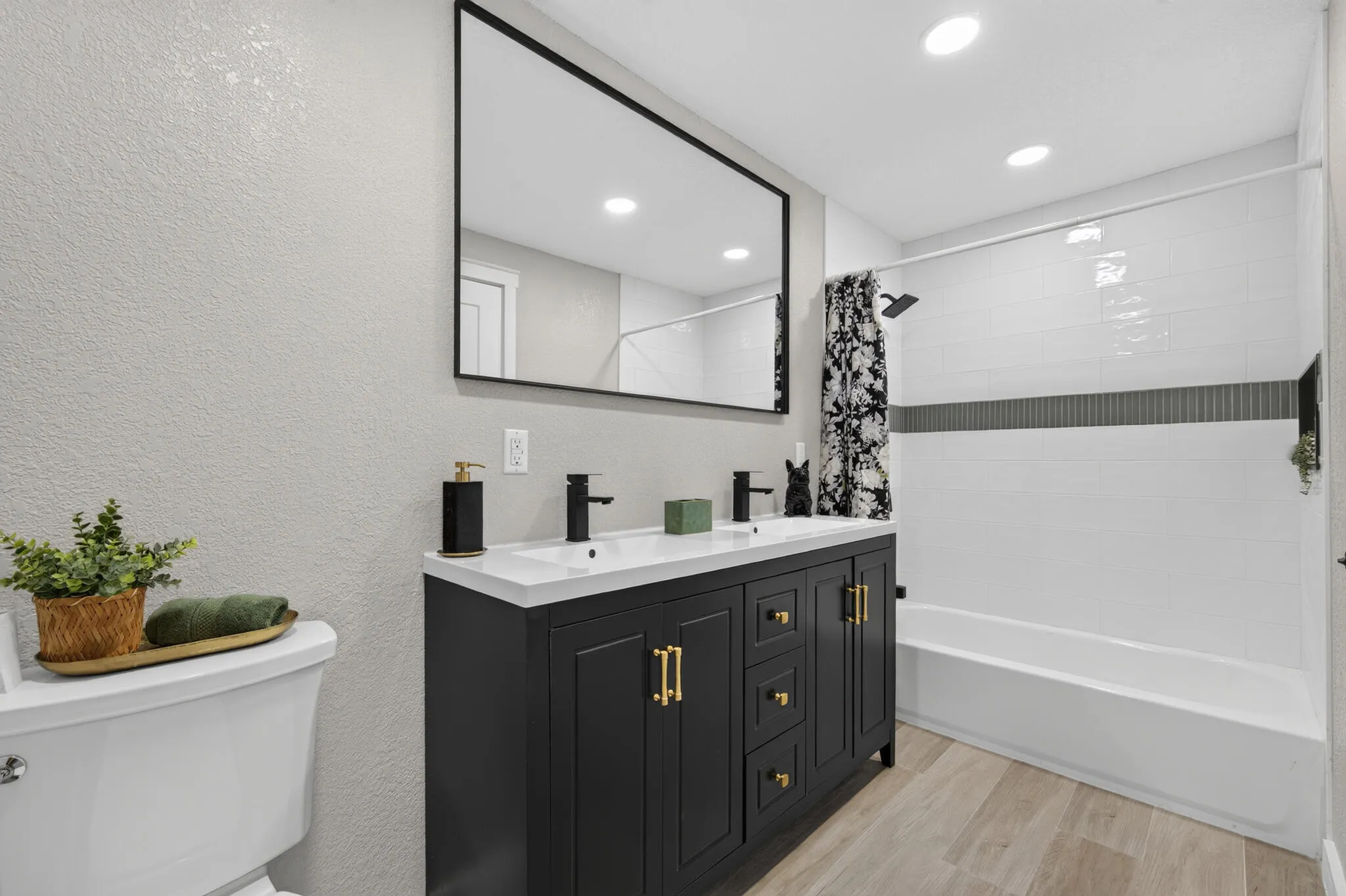 Dual vanity with matte black hardware, white rectangular sinks, and a large framed mirror.
