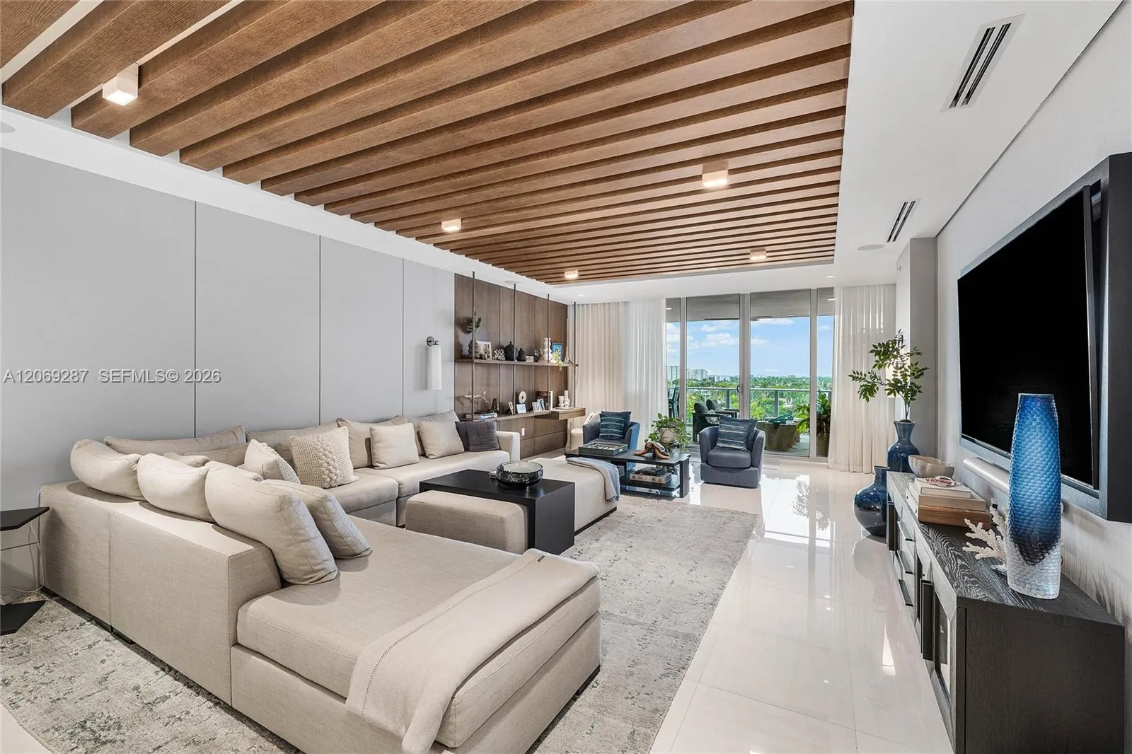 An expansive living room offering panoramic waterfront views and seamless access to the terrace.