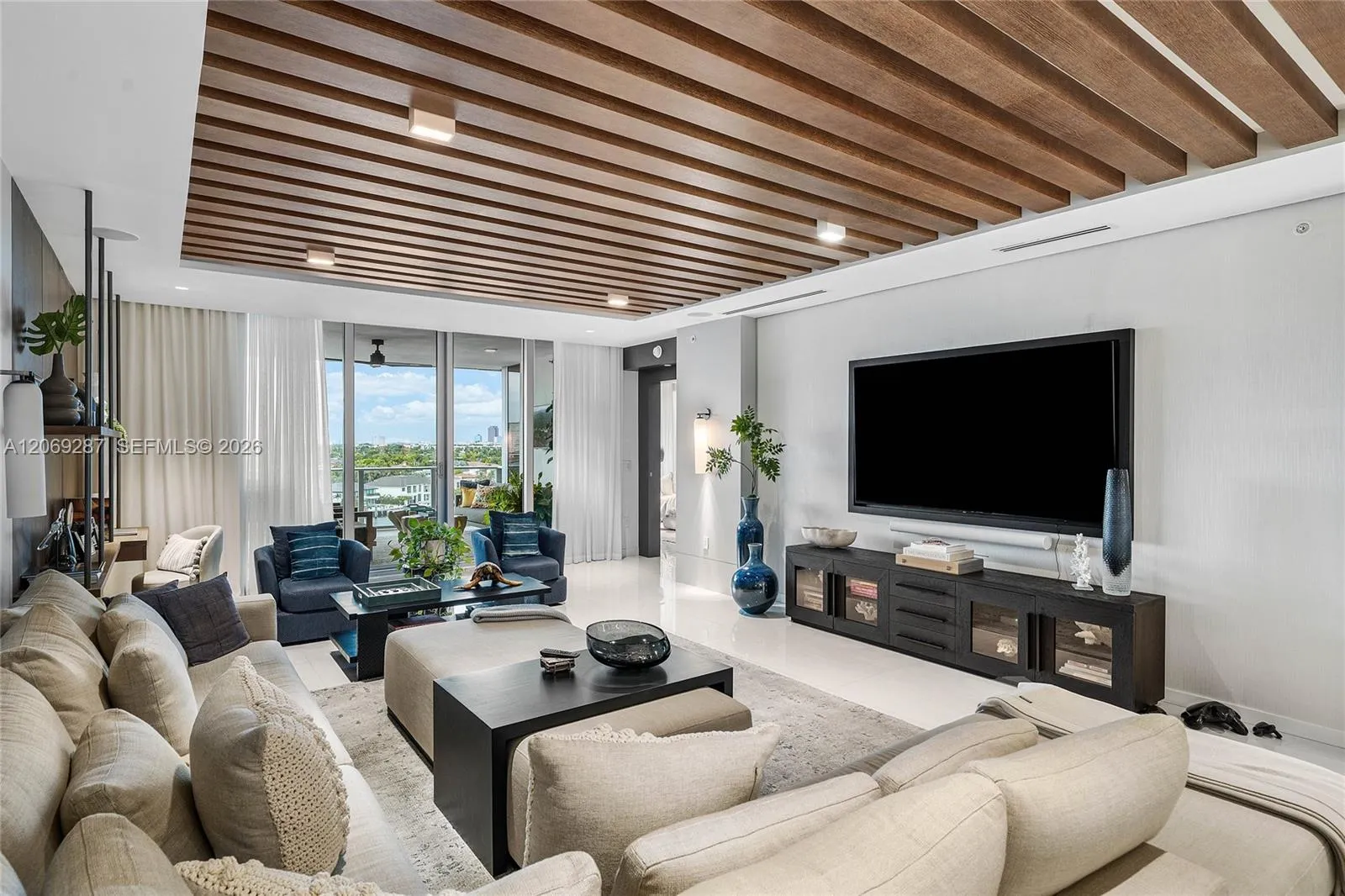 An expansive living room offering panoramic waterfront views and seamless access to the terrace.