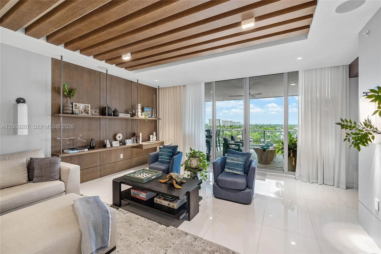 An expansive living room offering panoramic waterfront views and seamless access to the terrace.