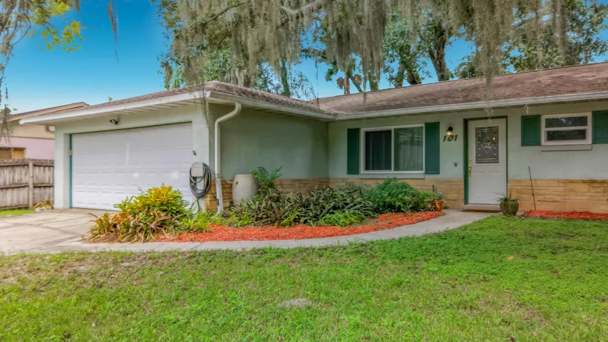 Single-story residence featuring a two-car garage, front walkway, and mature landscaping