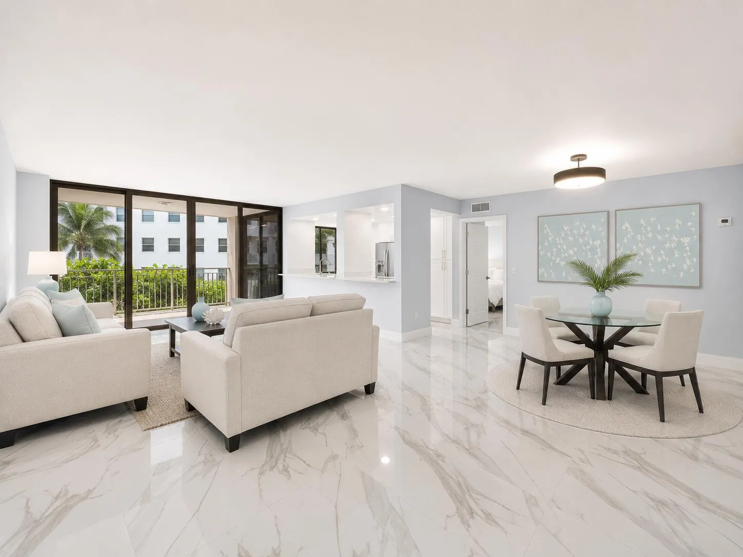 Polished light tile flooring throughout, bright recessed lighting, and a full-height impact glass sliding door opening to a private balcony. some furniture is virtually staged