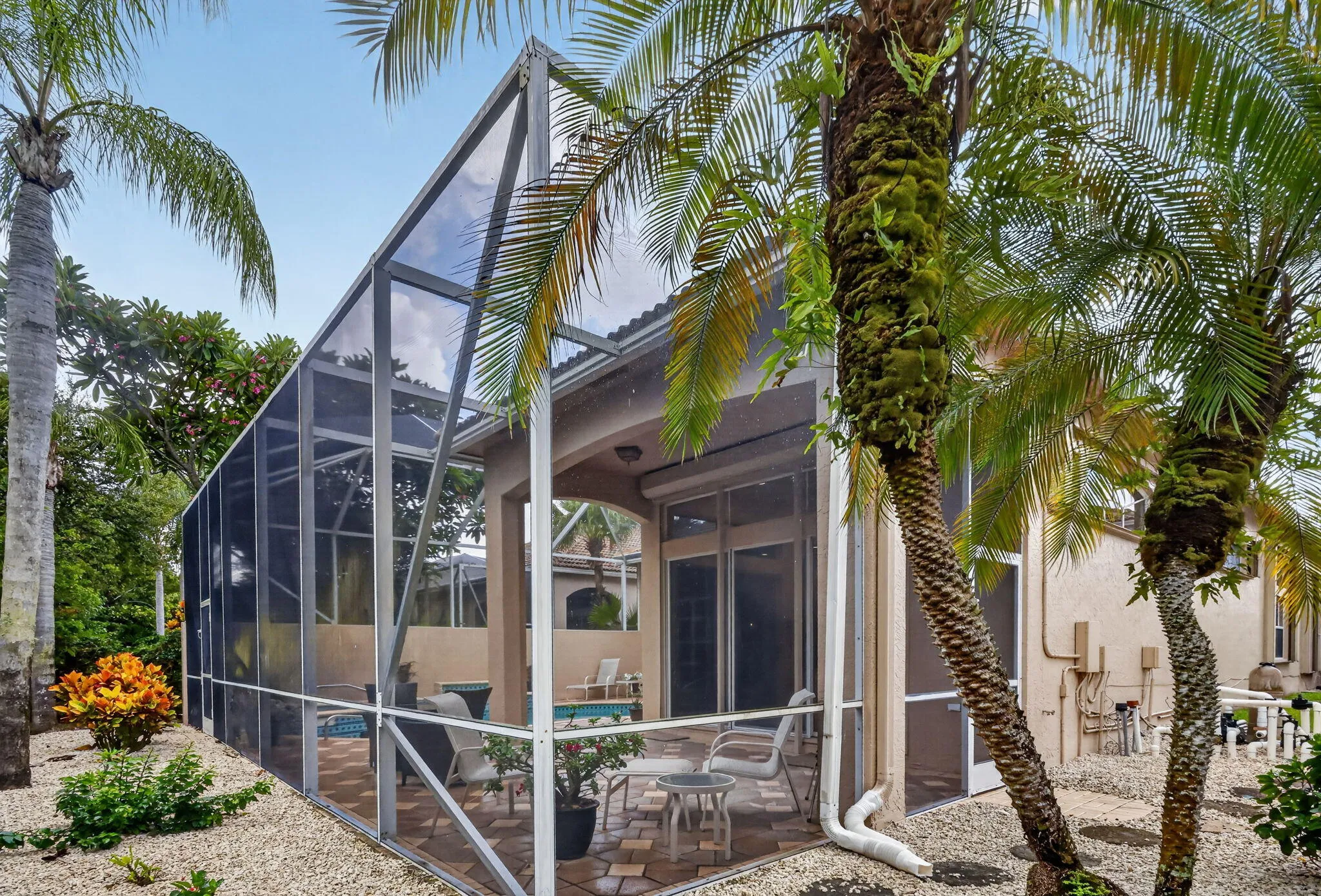 Screened-in enclosure with a covered patio and paved flooring