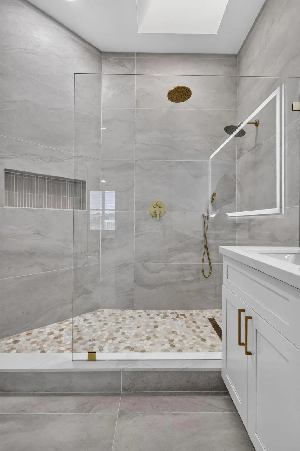 Walk-in shower with clear glass enclosure and a skylight